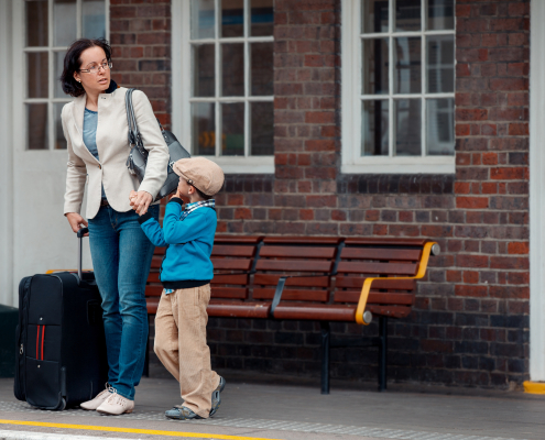 Waiting for a train with child and suitcase